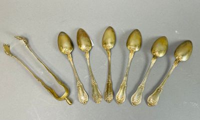 six cuillères et une fourchette sont disposées sur une table