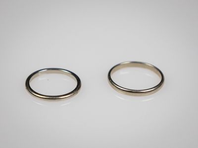 une paire de bagues en argent sur une surface blanche