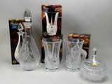trois vases en cristal et une boîte de bonbons posés sur une table