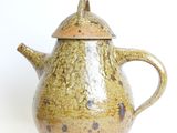 a brown teapot with a lid on a white background