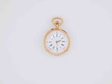 a close up of a gold pocket watch on a white surface