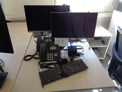 a desk with two computer monitors and a keyboard on it