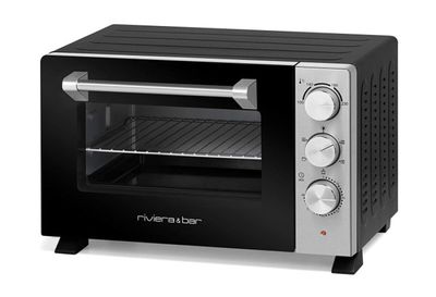 un four grille-pain noir et argent posé sur un plan de travail blanc