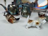 three figurines of dogs and a teapot on a table