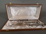 silverware in a wooden case on a table with a white cloth