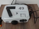 un petit projecteur avec une télécommande posé sur une table en bois