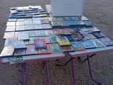 beaucoup de livres posés sur une table sur laquelle se trouve un ordinateur portable