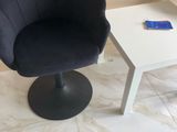 une chaise noire et une table blanche dans une pièce