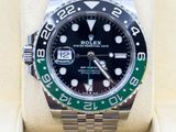a rolex watch with a green bezel on it