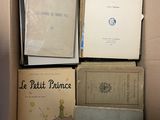une boîte remplie de livres posés sur le sol