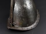 a metal helmet with a metal handle on a black surface