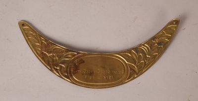 un gros plan d'une plaque en laiton posée sur une surface blanche