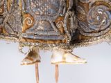 a close up of a gold and silver dress with beads on it