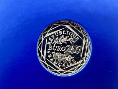 un gros plan d'une pièce d'argent posée sur une surface bleue