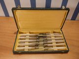 six pens in a case sitting on a table