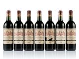 six bottles of wine are lined up on a white surface