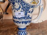 a blue and white pitcher sitting on a table next to a plate