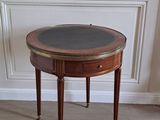 une petite table avec un plateau en verre, posée sur un sol recouvert de moquette