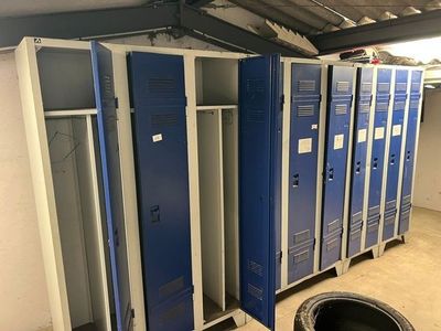 Plusieurs casiers bleus sont alignés les uns à côté des autres dans un garage