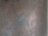 a close up of a metal vase with blue paint on it