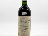 an old bottle of wine sitting on top of a white table