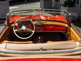 a red and tan convertible car parked in a parking lot