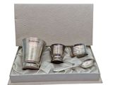 quatre tasses en acier inoxydable présentées dans un coffret cadeau sur fond blanc