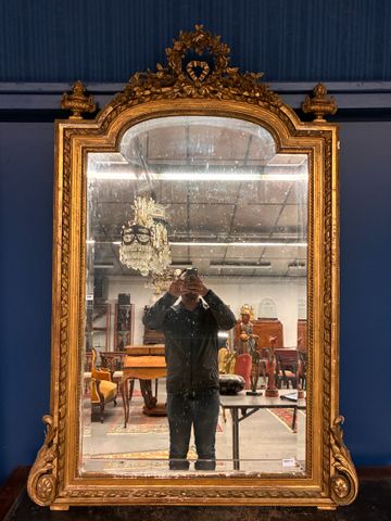 Grand miroir de cheminée en bois et stuc doré, Le fronton orné de...
