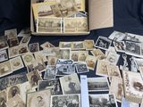 une vieille photo montrant un tas de vieilles photos dans une boîte posée sur une table