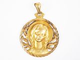 Gros plan sur un pendentif en or orné d'un visage de femme