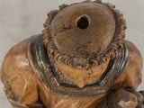a wooden statue of a man with a hat on his head