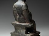 a statue of a woman sitting on a bench with her back to the camera
