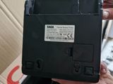 a person holding a black electronic device in front of a box