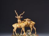 sculpture en bronze représentant deux cerfs sur un socle en bois