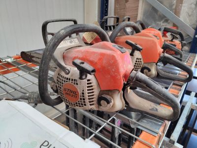 several chainsaws are lined up in a row on a rack