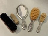 three brushes and a mirror sitting on a table