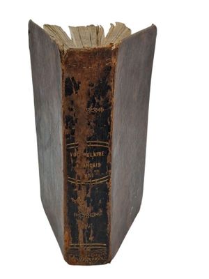 an old book sitting on top of a white surface