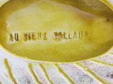 a close up of a yellow vase with writing on it