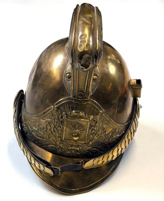 a metal helmet with a chain around it on a white surface
