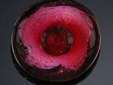 a glass bowl with a red flower inside of it