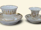two cups and saucers sitting on a saucer