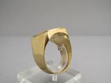 a close up of a gold ring on a clear stand