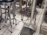 several stools and a table in a room with a lot of furniture
