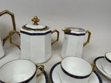 a white and blue tea set with gold trims