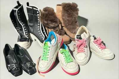 several pairs of shoes are lined up on a table next to a teddy bear
