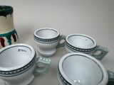 four cups and a vase sitting on a table