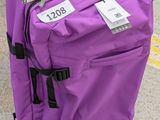 une valise violette avec une étiquette, posée par terre