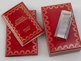 two red boxes with gold trimming and a lighter on top of them