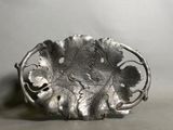 une assiette en argent ornée d'un motif de feuilles