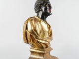 an antique bronze bust of a man with curly hair on a pedestal